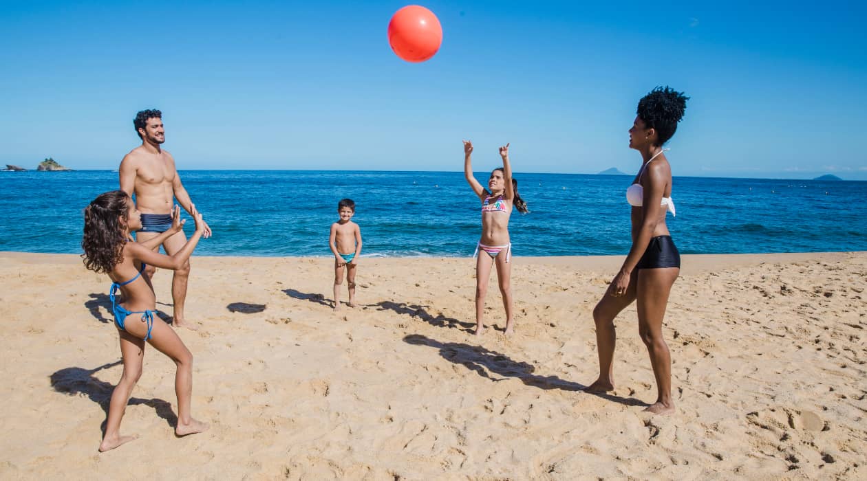 Una familia jugando al balón en la playa