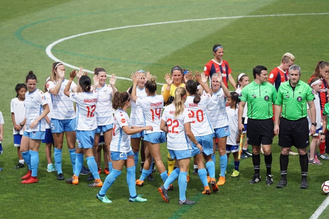 dos equipos de fútbol femenino saludándose al finalizar el partido