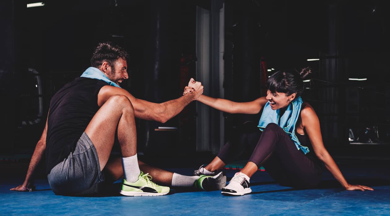 Un hombre y una mujer entrenando en un gimnasio