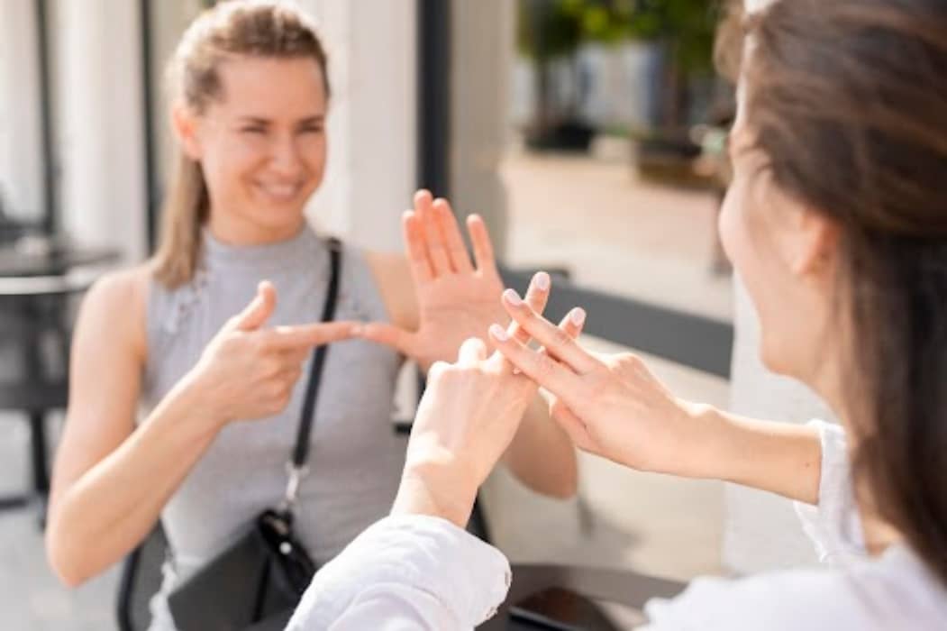 dos mujeres en un restaurante hablando en lengua de signos