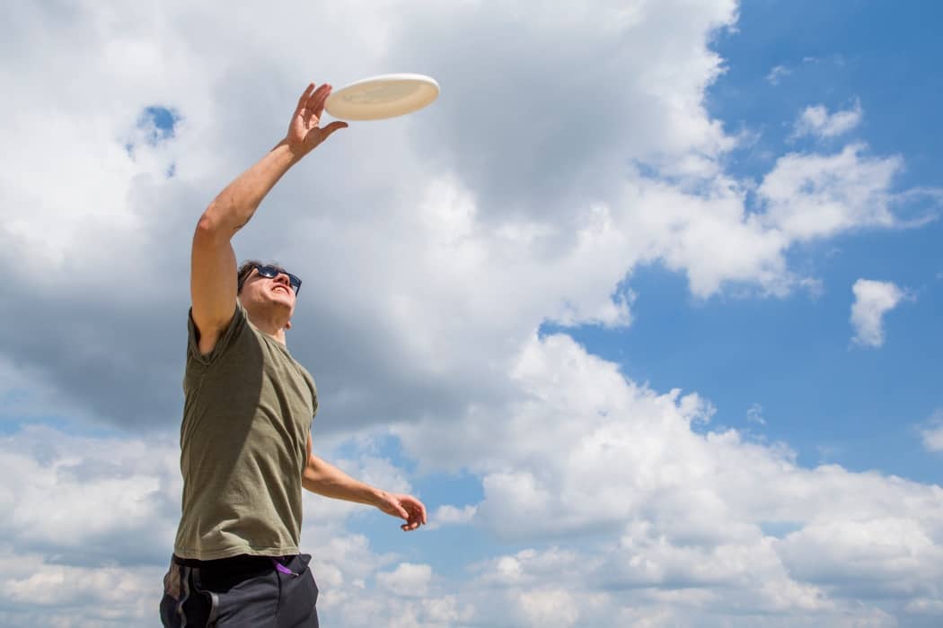 jugador de ultimate fresbee cogiendo el disco en el aire