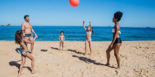 Una familia jugando al balón en la playa
