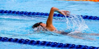 Mujer nadando en una de las calles de una piscina olímpica
