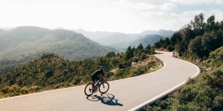 Un ciclista por al carretera al amanecer