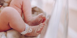 piernas de un bebé con pulsera identificativa dentro de una incubadora
