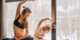 Madre embarazada haciendo ejercicio con su hija