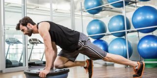 deportista en una sala de gimnasio haciendo ejercicio funcional con un bosu