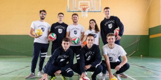 Grupo de alumnos de MEDAC posando como un equipo con balones de diferentes deportes