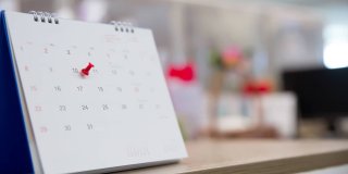 Primer plano de un calendario con una chincheta marcando la fecha importante