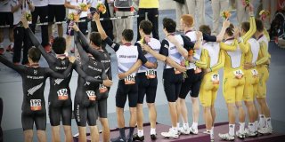 Atletas de Reino Unido, Australia y Nueva Zelanda de espaldas saludando al público en un podio olímpico