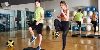 Una mujer y un hombre en una clase de actividad muscular en una sala de ejercicio