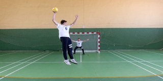 Dos chicos en una pista practicando tiros de balonmano