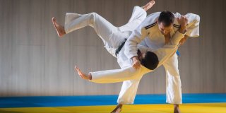 Dos hombres practicando una técnica de judo en un tatami