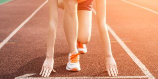 Persona preparándose en una pista de atletismo