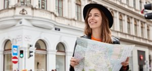 Turista en la calle consultando el mapa turístico de una ciudad