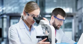 técnicos de laboratorio revisando muestras biomédicas en microscopio
