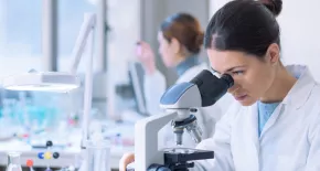 Técnico de laboratorio analizando una muestra en un microscopio