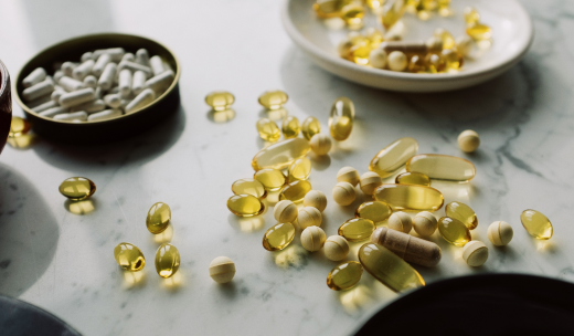 Primer plano de diferentes suplementos dietéticos esparcidos por una mesa