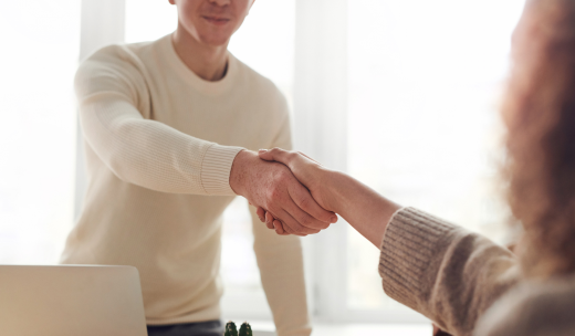 Dos personas dándose la mano en señal de acuerdo
