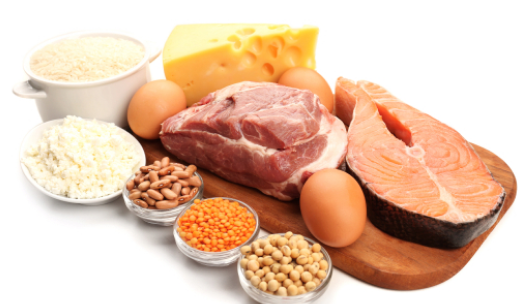Legumbres, huevos, carne, salmón y queso colocados encima de una tabla