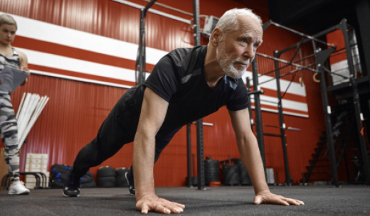 Un hombre mayor haciendo plancha en un gimnasio