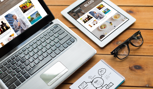 Blog de contenido en diferentes dispositivos electrónicos sobre un escritorio de madera