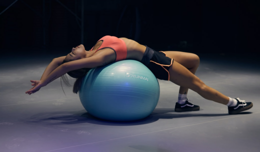 Mujer deportista estirando sobre un fitball