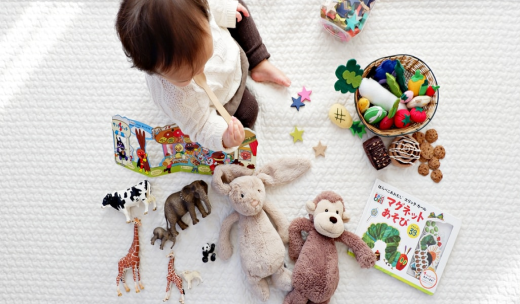 Vista desde arriba de un bebé con peluches de animales y juguetes alrededor