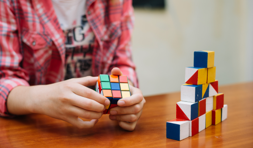 Primer plano de un niño practicando con un cubo de rubik