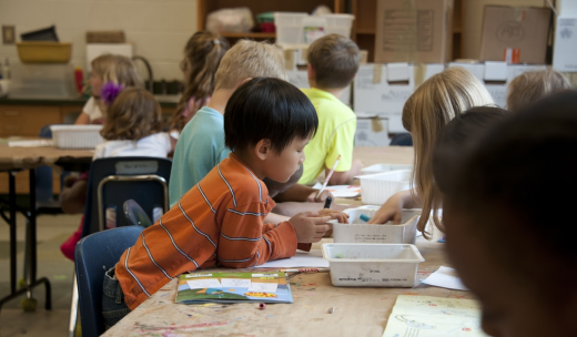 Niños pequeños en clase realizando actividades con cera de colores