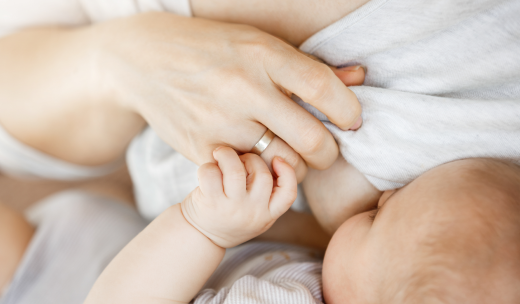 Primer plano de un bebé mamando del pecho de su madre