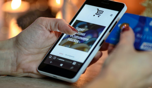 Primer plano de las manos de una persona comprando en un marketplace desde su móvil