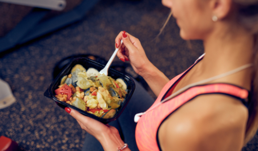 Primer plano de una mujer comiendo un plato de verduras