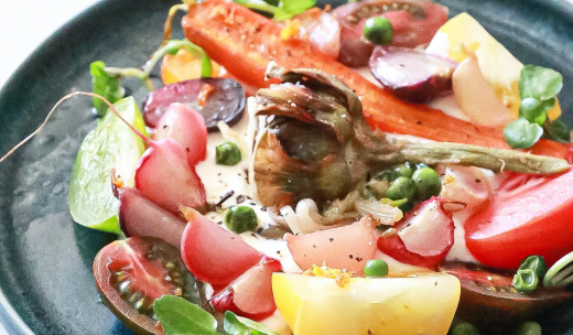 Primer plano de un plato con tomate, guisantes, rábano y otras verduras
