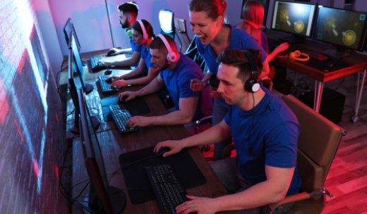Equipo de esports compitiendo mientras su entrenadora celebra una jugada