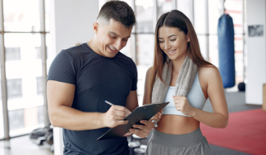 Preparador físico y deportista charlando sonrientemente sobre el entrenamiento deportivo