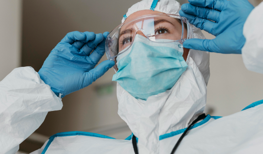 Primer plano de una sanitaria poniéndose el equipo de EPI