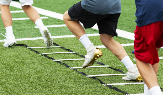 Primer plano de piernas de jugadores de fútbol entrenando en el césped