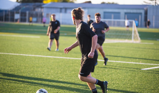 Jóvenes jugadores en un campo de fútbol jugando un partido