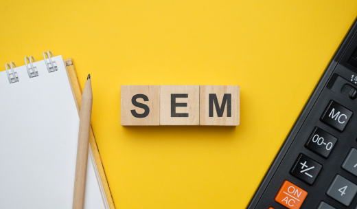 Letras de scrabble con la palabra SEM junto a una libreta y una calculadora