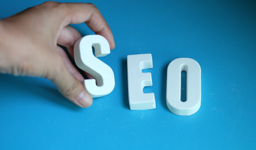 Mano cogiendo unas letras blancas de SEO