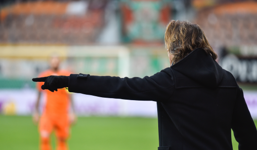 Entrenador de fútbol dando una orden a un jugador en el terreno de juego