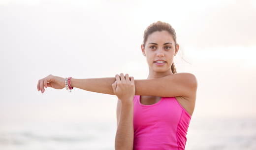 Mujer en primer plano realizando estiramientos de brazo