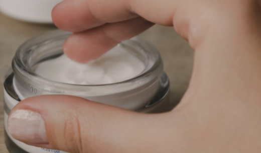 Una mano y un bote de crema
