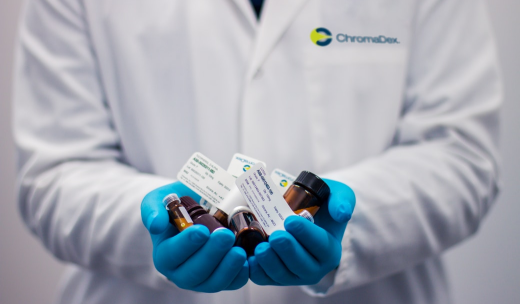 Un farmacéutico cogiendo entre sus manos con guantes diferentes productos