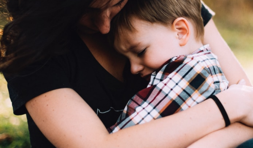 Una mujer abrazando a un niño pequeño