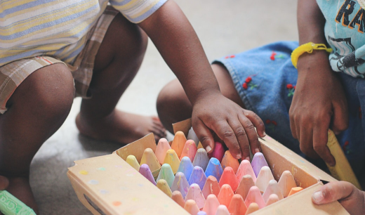 Niños abriendo una caja de tizas de colores