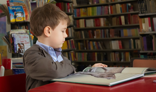 Niño en una librería leyendo un libro