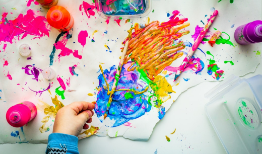 Papel con pintura y una mano de un niño