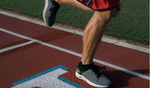 Piernas corriendo en una pista de atletismo